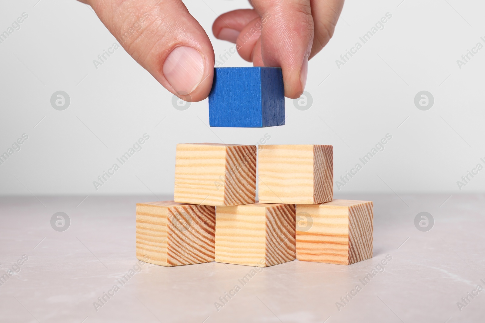 Photo of Woman with wooden cubes at light table, closeup