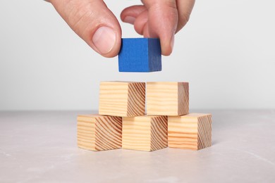 Woman with wooden cubes at light table, closeup