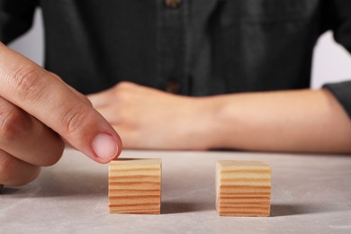 Woman with wooden cubes at light table, closeup