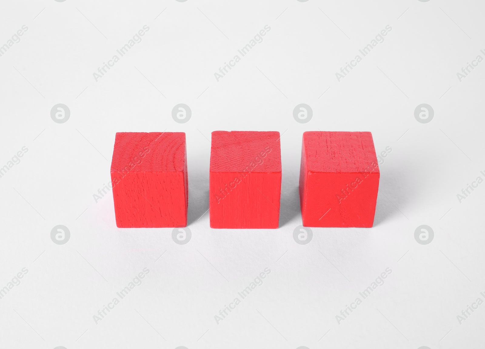 Photo of Many red wooden cubes isolated on white