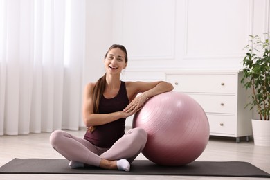 Photo of Beautiful pregnant woman with fitball on exercise mat at home