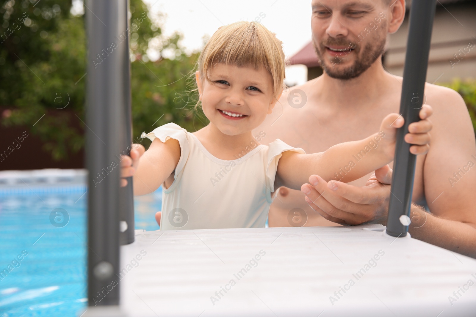 Photo of Happy daughter and her father in swimming pool