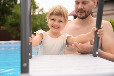 Happy daughter and her father in swimming pool