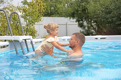 Daughter and her father having fun in swimming pool