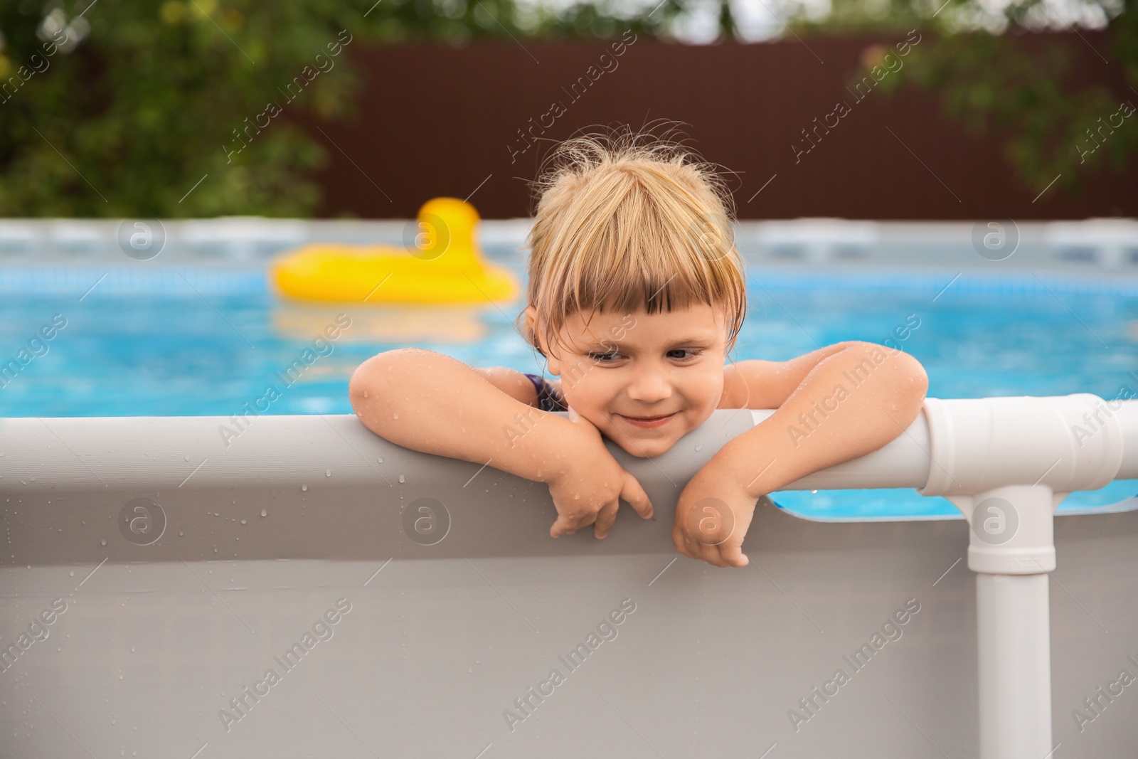 Photo of Little girl resting in swimming pool outdoors, selective focus