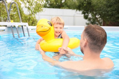 Happy daughter and her father having fun in swimming pool