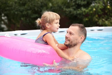 Daughter and her father having fun in swimming pool