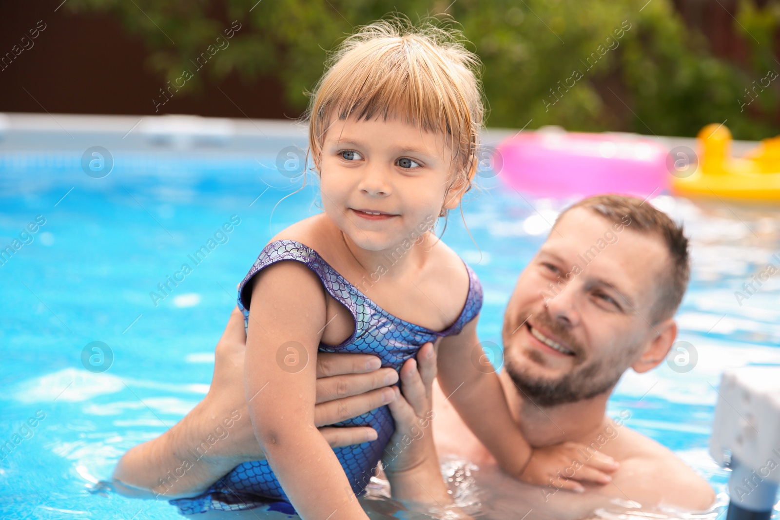 Photo of Daughter and her father having fun in swimming pool