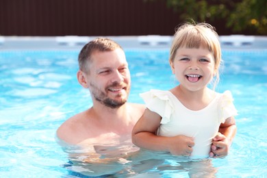 Happy father having fun with his daughter in swimming pool