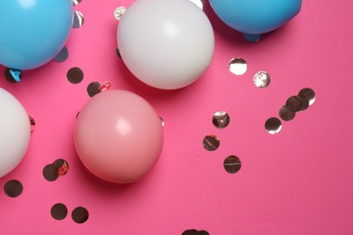 Photo of Shiny golden confetti and air balloons on bright pink background, flat lay