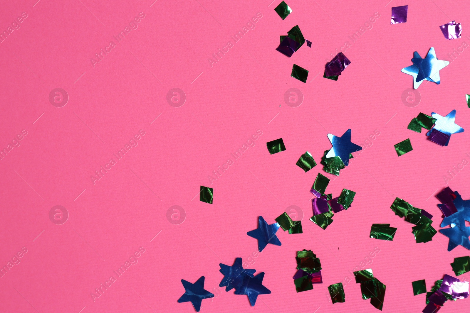 Photo of Shiny confetti on bright pink background, top view. Space for text