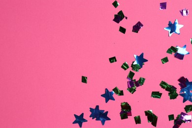 Shiny confetti on bright pink background, top view. Space for text