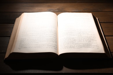 Photo of Open Bible on wooden table, closeup. Christian faith