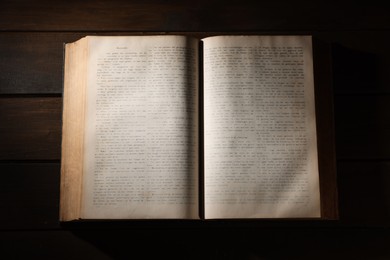 Photo of Open Bible on wooden table, top view