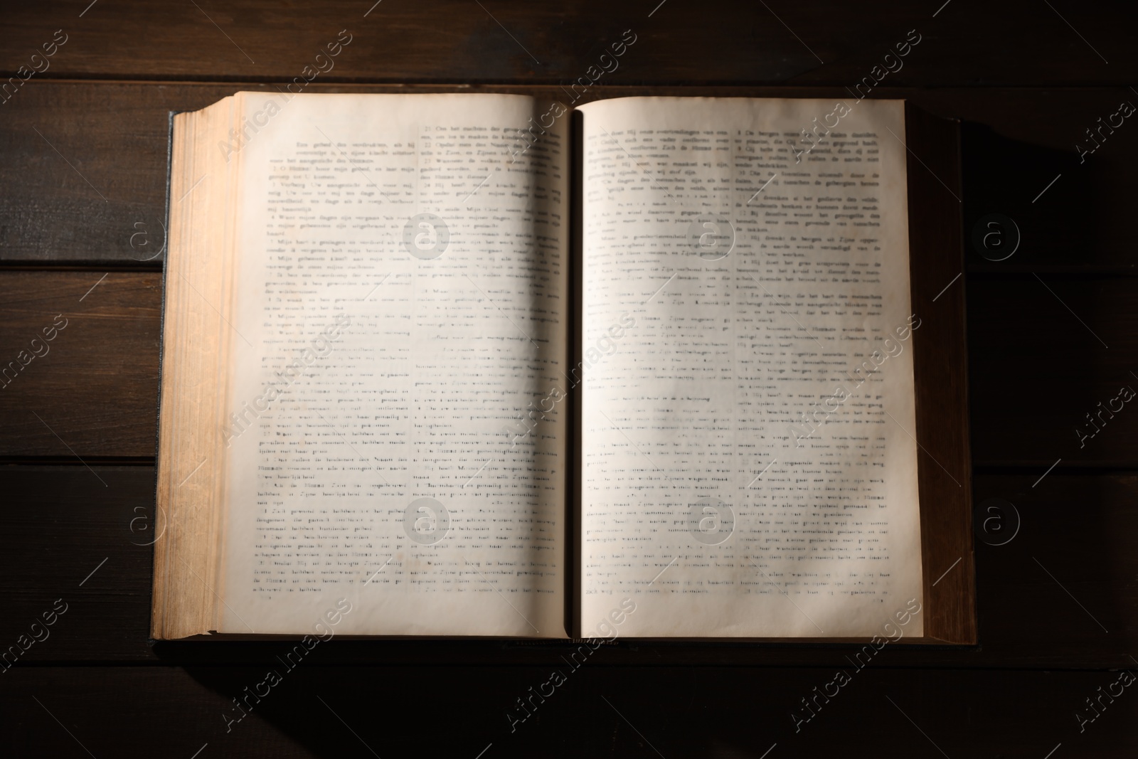 Photo of Open Bible on wooden table, top view