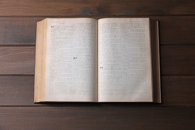 Photo of Open Bible on wooden table, top view