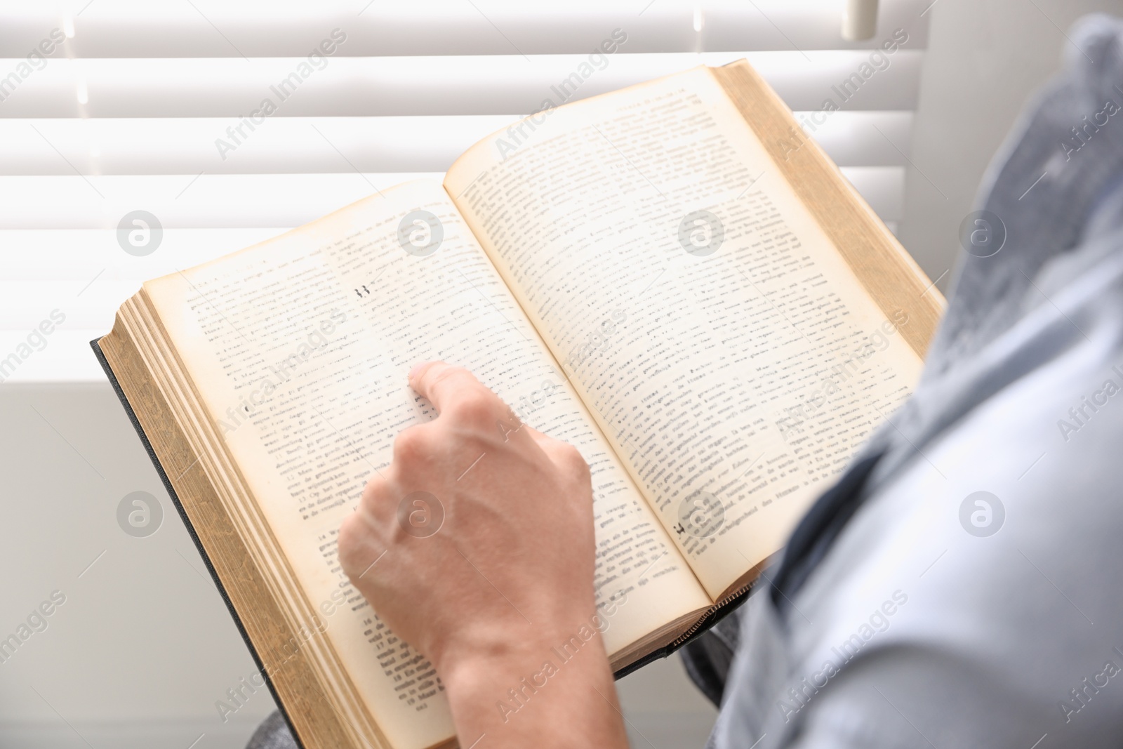 Photo of Man with Bible indoors, closeup. Christian faith