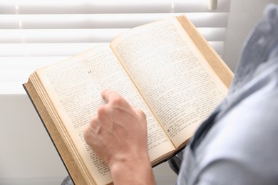 Photo of Man with Bible indoors, closeup. Christian faith