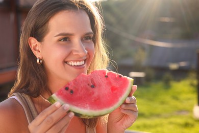 Happy woman with slice of juicy watermelon outdoors