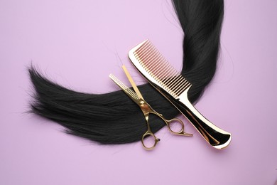 Photo of Black hair strand, comb and professional scissors on violet background, top view