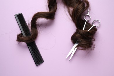 Brown hair strand, comb and professional scissors on violet background, top view