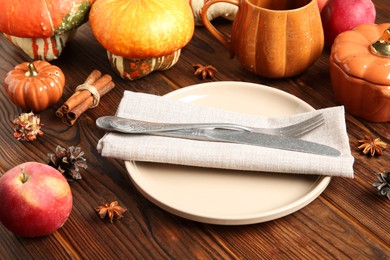 Photo of Stylish place setting with autumn decor on wooden table