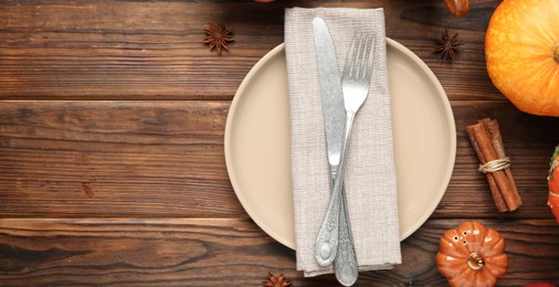 Photo of Stylish place setting and autumn decor on wooden table. Space for text