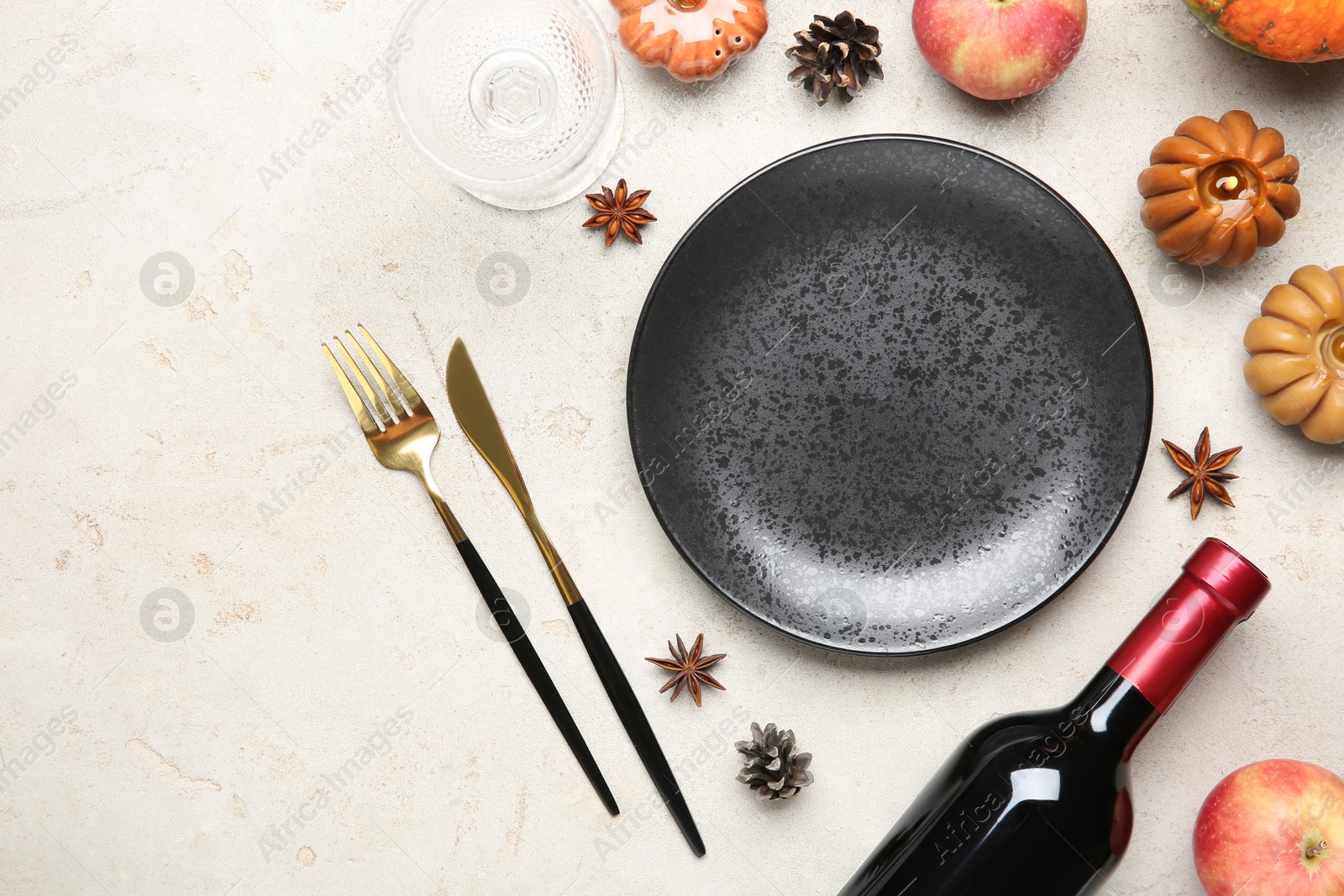 Photo of Stylish place setting, bottle of wine and autumn decor on grey textured table. Space for text