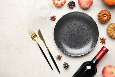 Photo of Stylish place setting, bottle of wine and autumn decor on grey textured table. Space for text