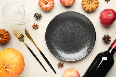 Photo of Stylish place setting, bottle of wine and autumn decor on grey textured table