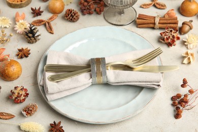 Photo of Stylish place setting, cinnamon and dry flowers on grey textured table