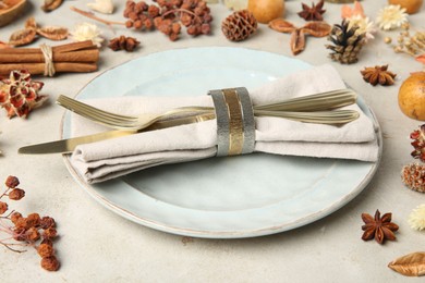 Photo of Stylish place setting, cinnamon and dry flowers on grey textured table