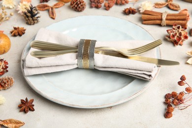 Photo of Stylish place setting, cinnamon and dry flowers on grey textured table