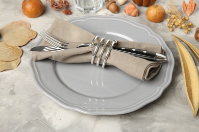 Photo of Stylish place setting and autumn decor on grey textured table, closeup