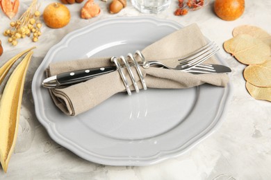 Stylish place setting and autumn decor on grey textured table, closeup