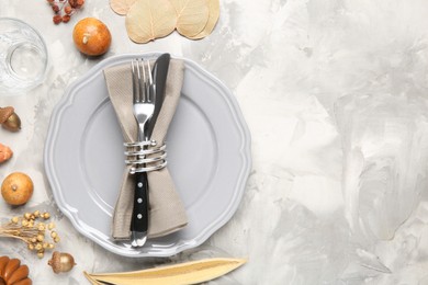 Stylish place setting, cinnamon and dry flowers on grey textured table. Space for text