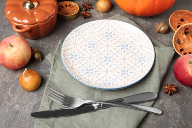 Stylish place setting and autumn decor on grey textured table