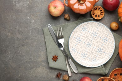 Stylish place setting and autumn decor on grey textured table. Space for text