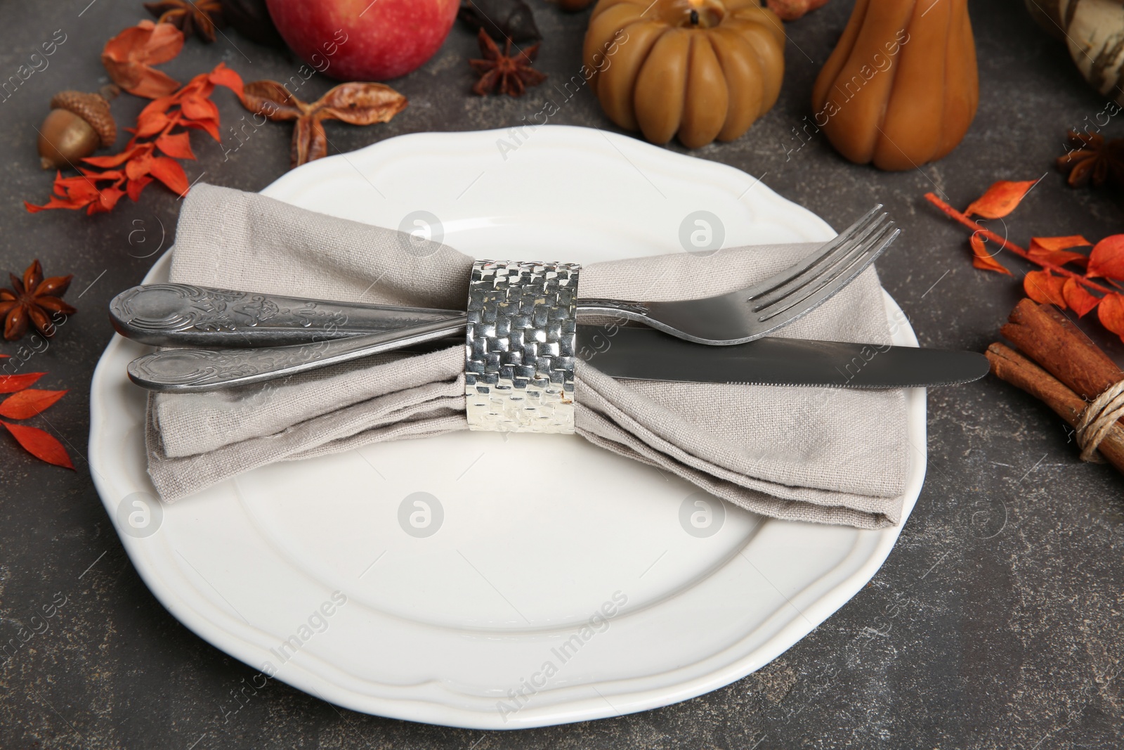 Photo of Stylish place setting and autumn decor on grey textured table, closeup