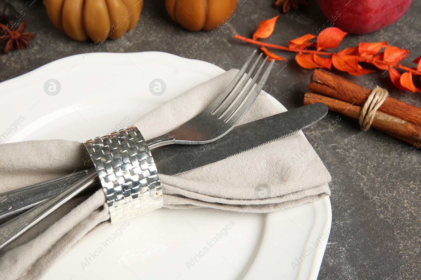 Photo of Stylish place setting and autumn decor on grey textured table, closeup