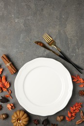 Stylish place setting and autumn decor on grey textured table. Space for text