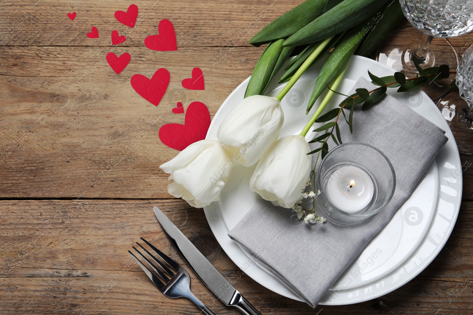 Image of Table setting for romantic Valentine's day celebration, top view. Plates, cutlery, flowers and hearts on wooden table, space for text