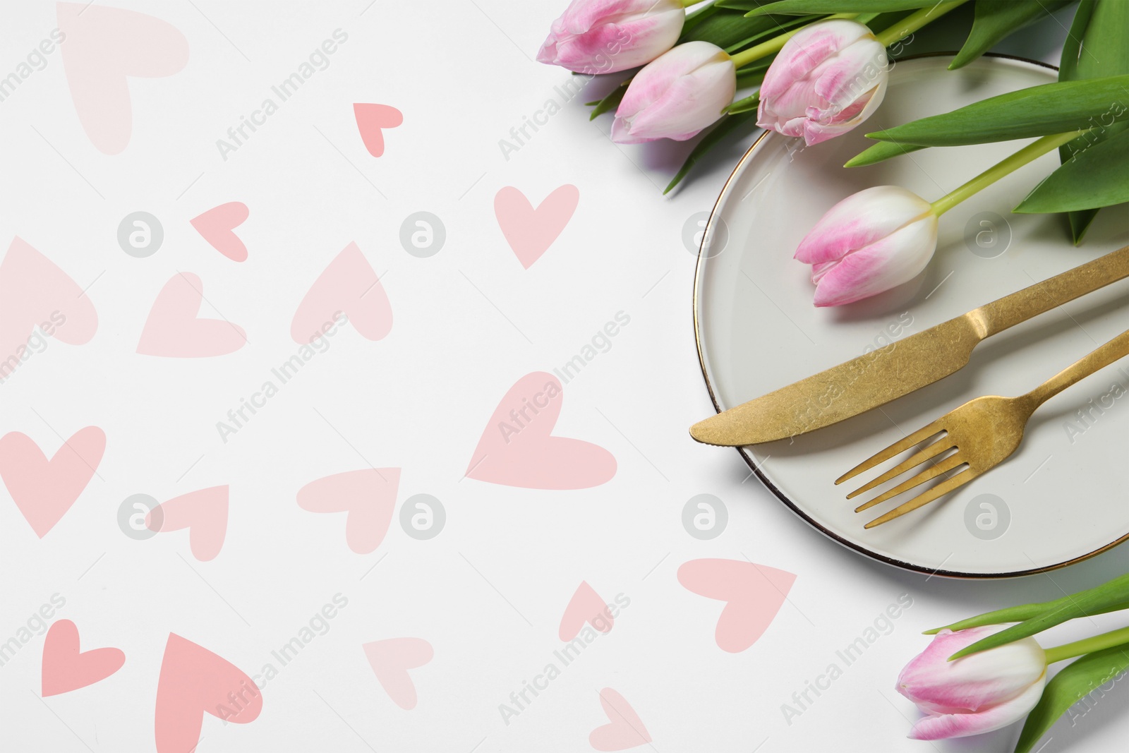 Image of Table setting for romantic Valentine's day celebration, top view. Plate, cutlery, flowers and hearts on white table, space for text