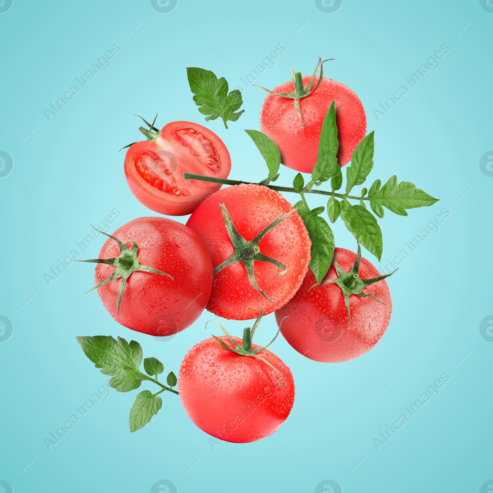 Image of Fresh tomatoes with green leaves in air on light blue background