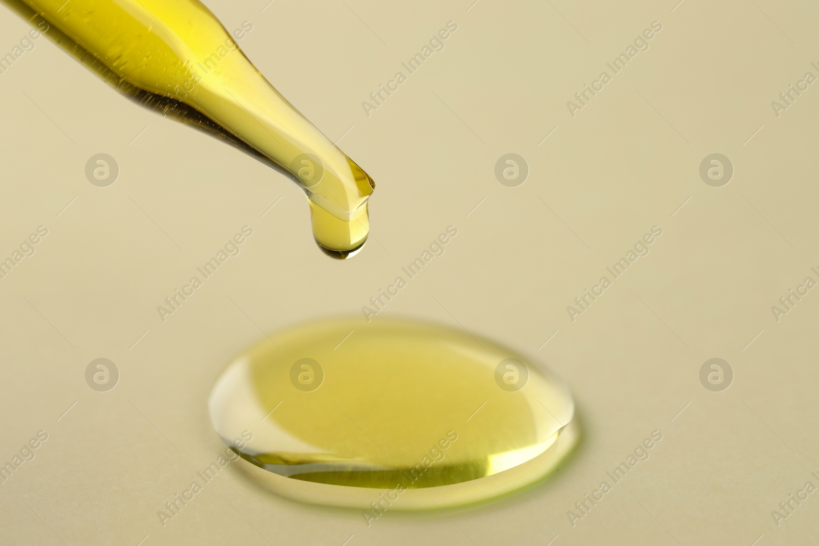 Photo of Cosmetic oil dripping from pipette on dark beige background, closeup. Space for text