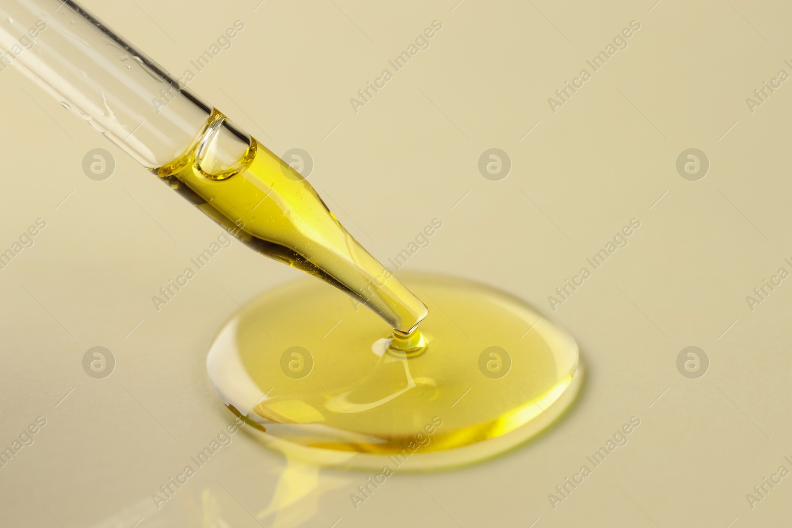 Photo of Cosmetic oil dripping from pipette on dark beige background, closeup. Space for text