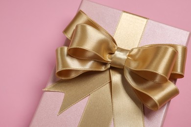 Photo of Gift box with bow on dusty pink background, closeup