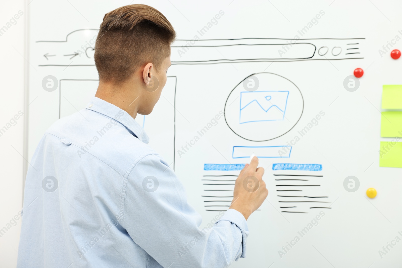 Photo of Developing UI design. Man drawing website wireframe on whiteboard indoors