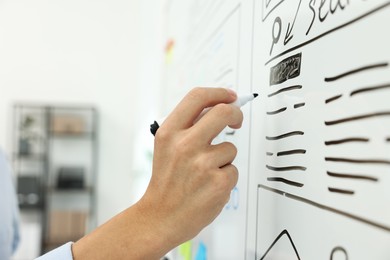 Developing UI design. Man drawing website wireframe on whiteboard indoors, closeup