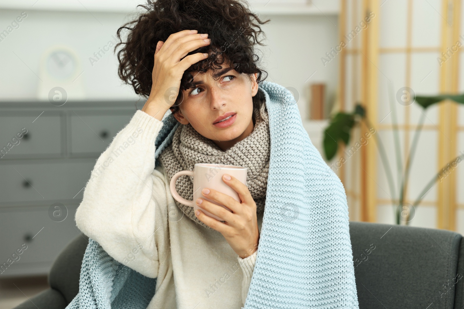 Photo of Cold symptom. Young woman with cup of hot drink at home